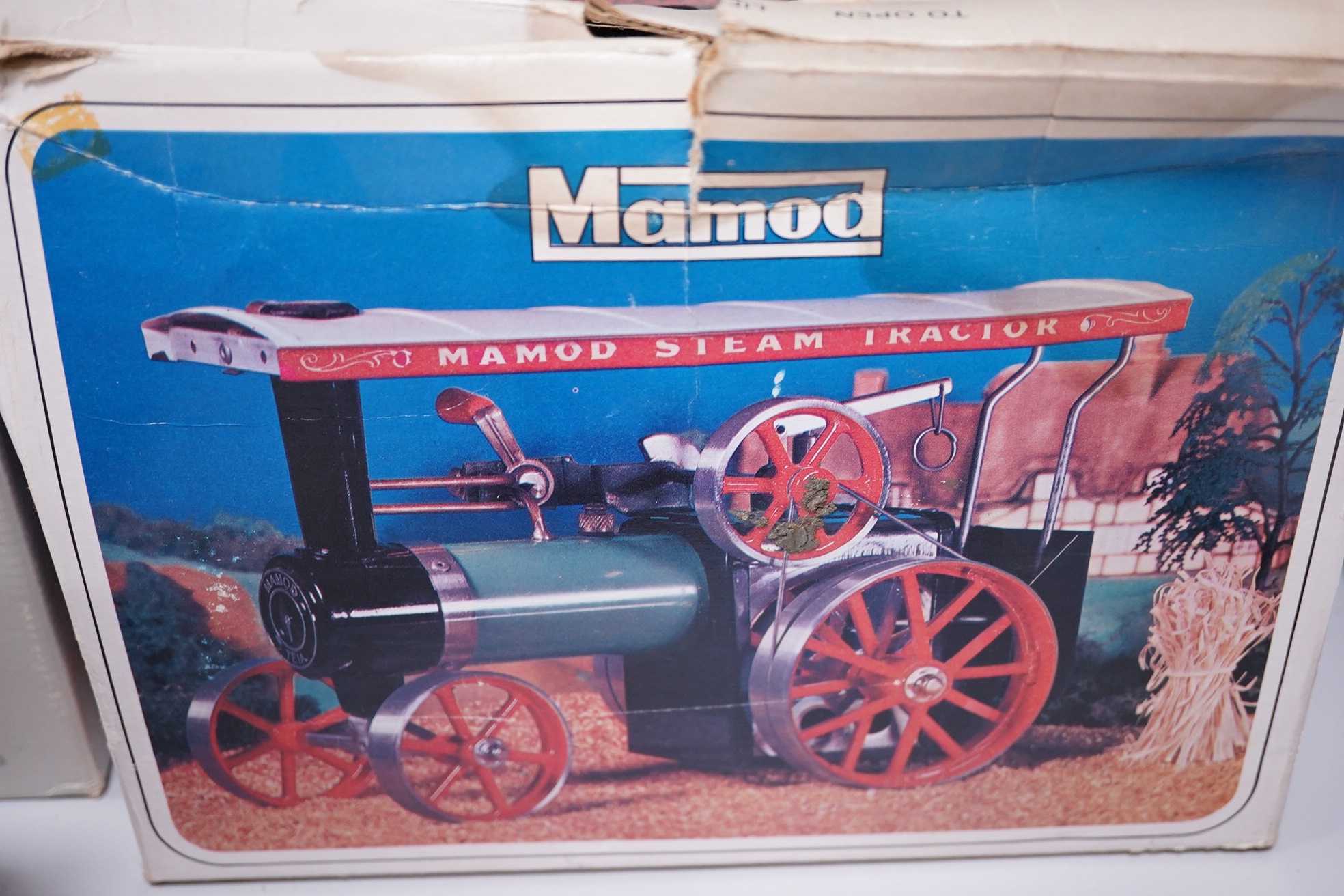 A boxed Mamod TE-1A live steam traction engine and lumber wagon. Condition - poor to fair, there is corrosion to the exposed aluminium and other metal parts.